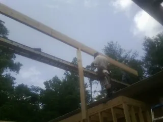 Carpenter setting a ridge beam over a new addition frame — Ice Dam Removal by Roofing Brothers in New London